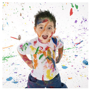 Adorable 3 year old boy covered in bright paint.