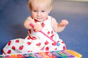 baby girl playing toy xylophone