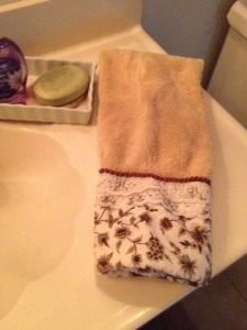 a folded hand towel, near a clean sink